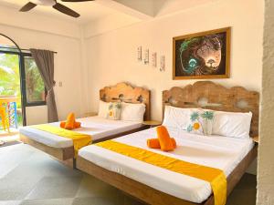 two beds in a room with orange pillows at Stone Manor Inn in Concepcion +165 photos