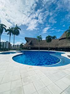 a large swimming pool with palm trees and a building at Apartamento Campestre con Confort y Exclusividad in Flandes
