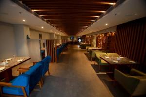 a restaurant with tables and chairs and a long corridor at Ambal Regency in Pudukād