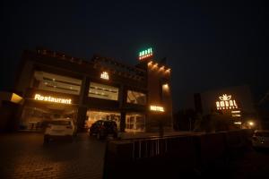 a parking lot in front of a restaurant at night at Ambal Regency in Pudukād