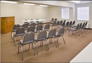 a conference room with chairs and a table and a podium at Comfort Crest Inn Smackover in Smackover