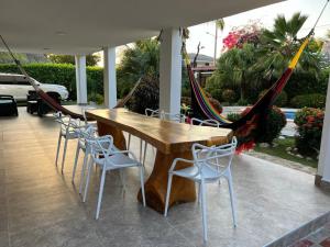 a wooden table and chairs on a patio with a hammock at House Villa Las Marias in Juan de Acosta