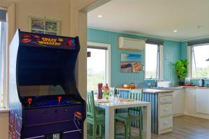 a kitchen with a game machine in the middle of a kitchen at Classic Charm, Sea & Mountain Views, Family Fun - KK95170 in Kaikoura