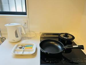 a kitchen counter with a pot on top of a stove at ASOBO OSAKA Kuromon 2nd in Osaka