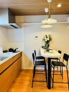 a kitchen with a table and chairs in a kitchen at ASOBO OSAKA Kuromon 2nd in Osaka +16 photos