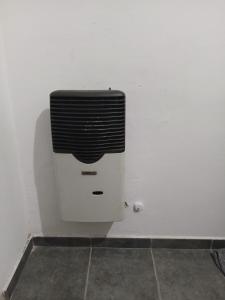 een witte muur met een zwarte en witte radiator bij Departamento cómodo in Jesús María