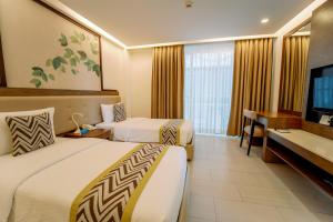 a hotel room with two beds and a flat screen tv at Boracay Haven Suites in Boracay