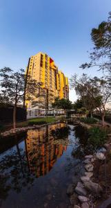 グアダラハラにあるHospedaje cerca Auditorio Telmex con A/Cの池の中の黄色い建物