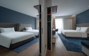 a hotel room with two beds and a tv at Holiday Inn Express Nanjing Happy Valley by IHG in Nanjing