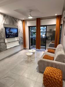 a living room with a couch and a tv at Hébergement La solitude in Les Abymes