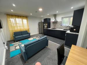 Una sala de estar con dos sofás y una cocina. en ROOM IN HARROW ON THE Hill, en Harrow