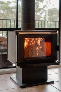 a stove with a fire in a room at Acacia at Boardwalk Villas in Metung +32 photos