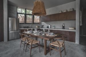 a kitchen with a wooden table and chairs in a kitchen at Jungle Luxury Villa Pvt Pool 100mbs AC Concierge D9 in Tulum