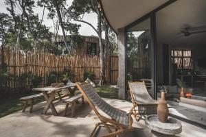 a patio with a table and chairs and a fence at Jungle Luxury Villa Pvt Pool 100mbs AC Concierge D9 in Tulum