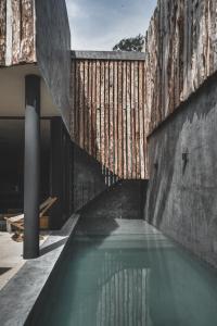 a swimming pool in a building with a wall at Jungle Luxury Villa Pvt Pool 100mbs AC Concierge D9 in Tulum