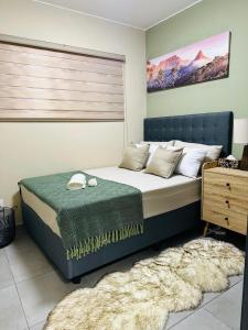Un dormitorio con una cama grande con una manta verde. en Olive view Retreat, en Midrand