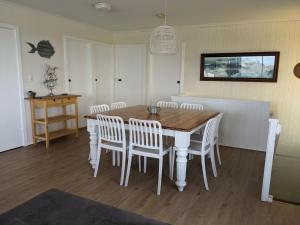 a dining room with a wooden table and white chairs at The Castle - Goolwa Beach in Goolwa South