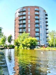 a building in front of a body of water at City View Apartments in Manchester