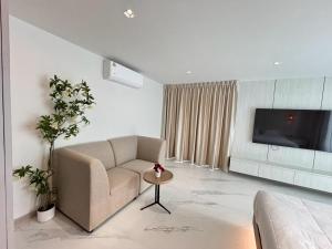 a living room with a couch and a tv at Mountain breeze villa phuket in Ban Bang Khu
