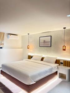 a bedroom with a large white bed with two pillows at Mountain breeze villa phuket in Ban Bang Khu
