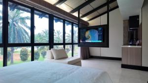 a bedroom with a bed and a tv and a chair at Urban Inn Cyberjaya in Cyberjaya