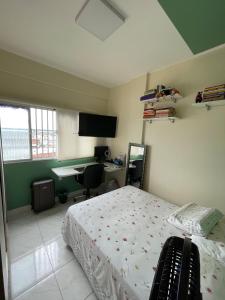 a bedroom with a bed and a desk and a monitor at COP30 - Apartamento próximo à UFPA in Belém