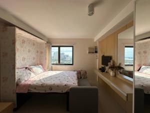 una piccola camera da letto con un letto e uno specchio di The Persimmon Mabolo Cebu City a Mabolo