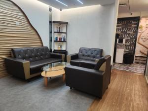 a waiting room with two couches and a table at Clock Inn Backpackers Hostel in Tanah Rata