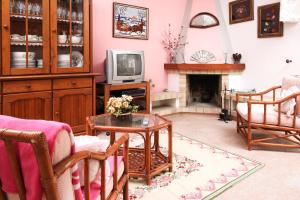 a living room with a fireplace and a tv at Vivenda Costa in Odeceixe