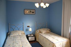 2 camas en una habitación con paredes azules en Sierra Pulide Apartamentos, en Salinas