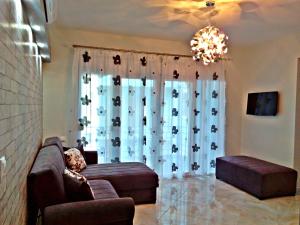 a living room with a couch and a window at Iro Apartment in Nea Peramos