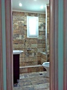 a bathroom with a shower and a sink and a toilet at Iro Apartment in Nea Peramos +7 photos
