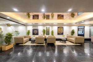 a lobby with a waiting room with chairs and tables at Saltstayz Premier - Paschim Vihar in New Delhi