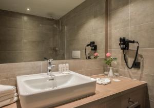 a bathroom with a sink and a bath tub at Radisson Blu Badischer Hof Hotel in Baden-Baden