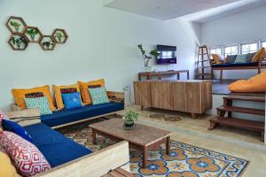 Una sala de estar con un sofá azul y una mesa. en Casarita Villa Jogja, en Jarakan