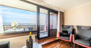 a room with a large window with a view of the ocean at PLAZA Hotel Föhr am Bodensee in Friedrichshafen +51 photos