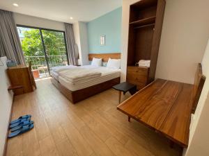 a bedroom with a bed and a large window at Laholm Hotel - Apartment in Nha Trang