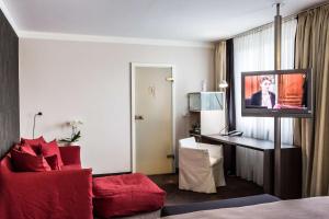 a hotel room with a couch and a flat screen tv at Best Western Premier Hotel Rebstock in Würzburg +97 photos