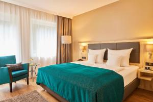 Rúm í herbergi á Best Western Premier Alsterkrug Hotel