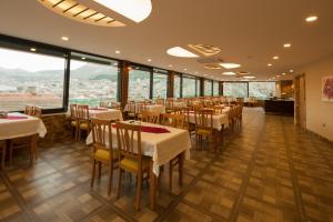 un restaurante con mesas, sillas y ventanas grandes en Armin Hotel, en Amasya