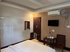 a bedroom with a bed and a tv and a chair at Thanh Thu 1 Hotel in Kon Tum (2)