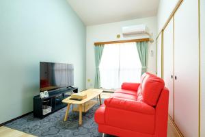 a living room with a red couch and a table at さくらハウス - Sakura house - 広々快適 最大6名滞在可 in Tokyo