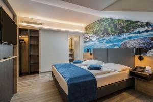 a bedroom with a bed and a painting on the wall at Best Western Hotel München Airport in Erding +79 photos