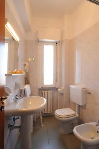 La salle de bains blanche est pourvue de toilettes et d'un lavabo. dans l'établissement Hotel Tritone, à Laigueglia