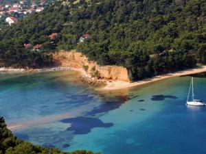 ein Segelboot im Wasser neben einem Strand in der Unterkunft Holiday Home Jaga - Three bedroom Holiday Home with swimming pool in Biograd na Moru