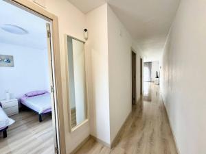 pasillo con espejo y cama en la habitación en Apartsalou Barbastre, en Salou