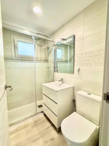 Un baño blanco con inodoro y lavabo. en Apartsalou Barbastre, en Salou 14 fotos más