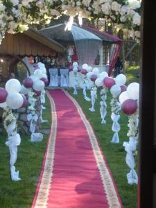 a aisle with white and purple balloons and a red carpet at Agroturystyka Uroczysko in Sianów +48 photos