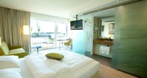 a bedroom with a large white bed and a bathroom at Best Western Plus Hotel Bremerhaven in Bremerhaven +76 photos