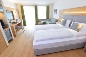 a large bedroom with two beds and a living room at Alpenhof Oberstdorf Hotel & SPA, Signature Collection by BW in Oberstdorf